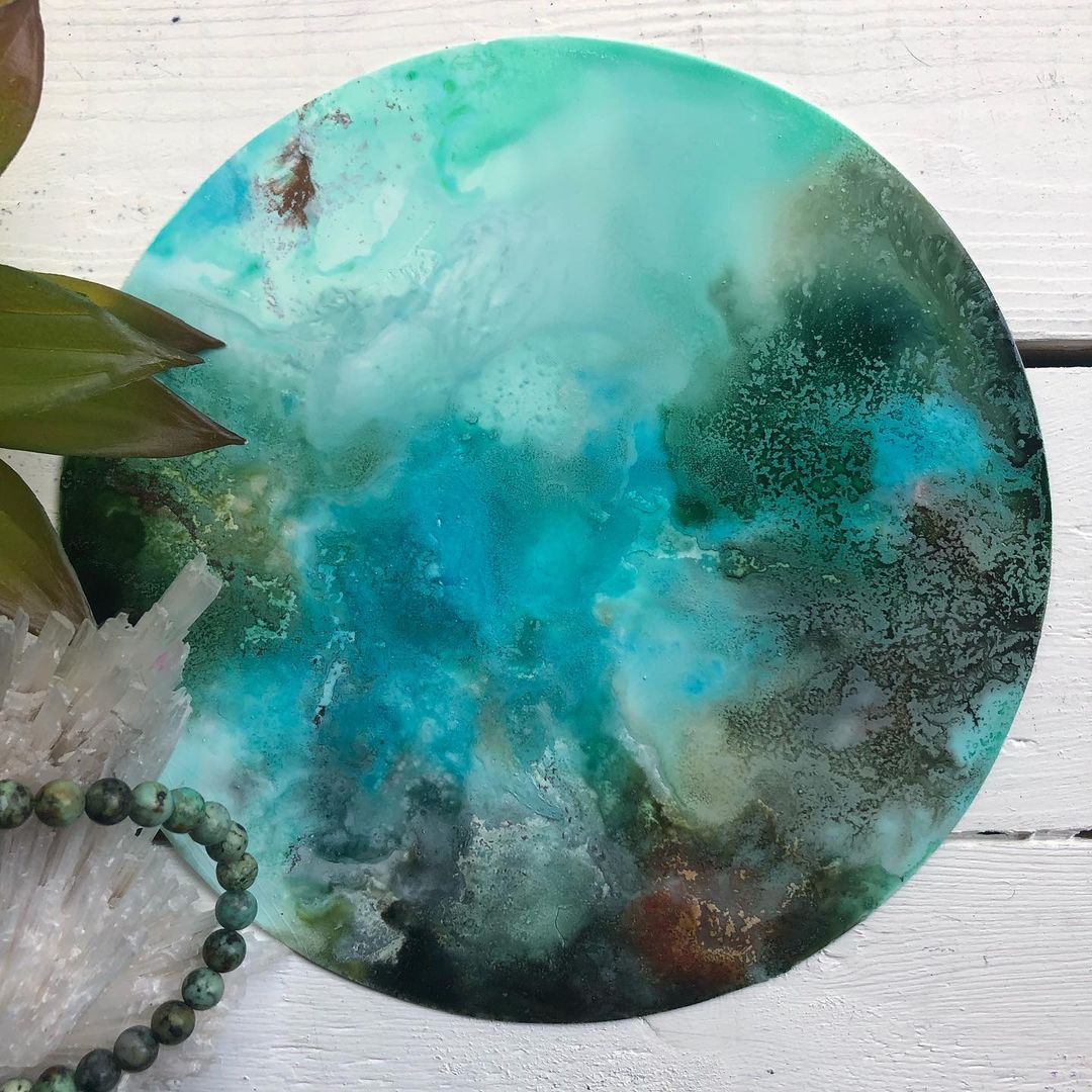 Abstract circular alcohol ink art in blue green shades with crystal and stone beads on white wood by t-rex inks
